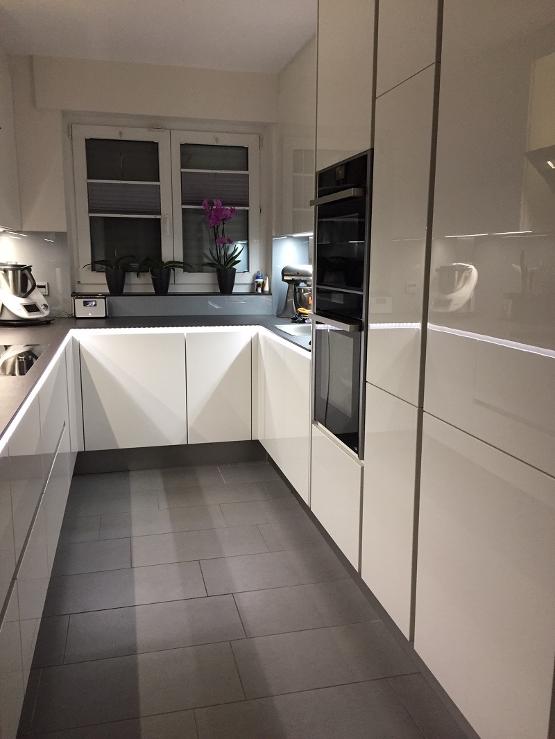 Blick in eine u-förmige Grifflosküche mit beleuchteter Griffmulde