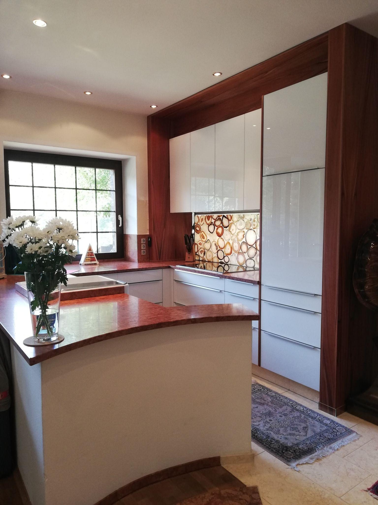 Helle Küche mit roten Akzenten und einer roten Arbeitsplatte