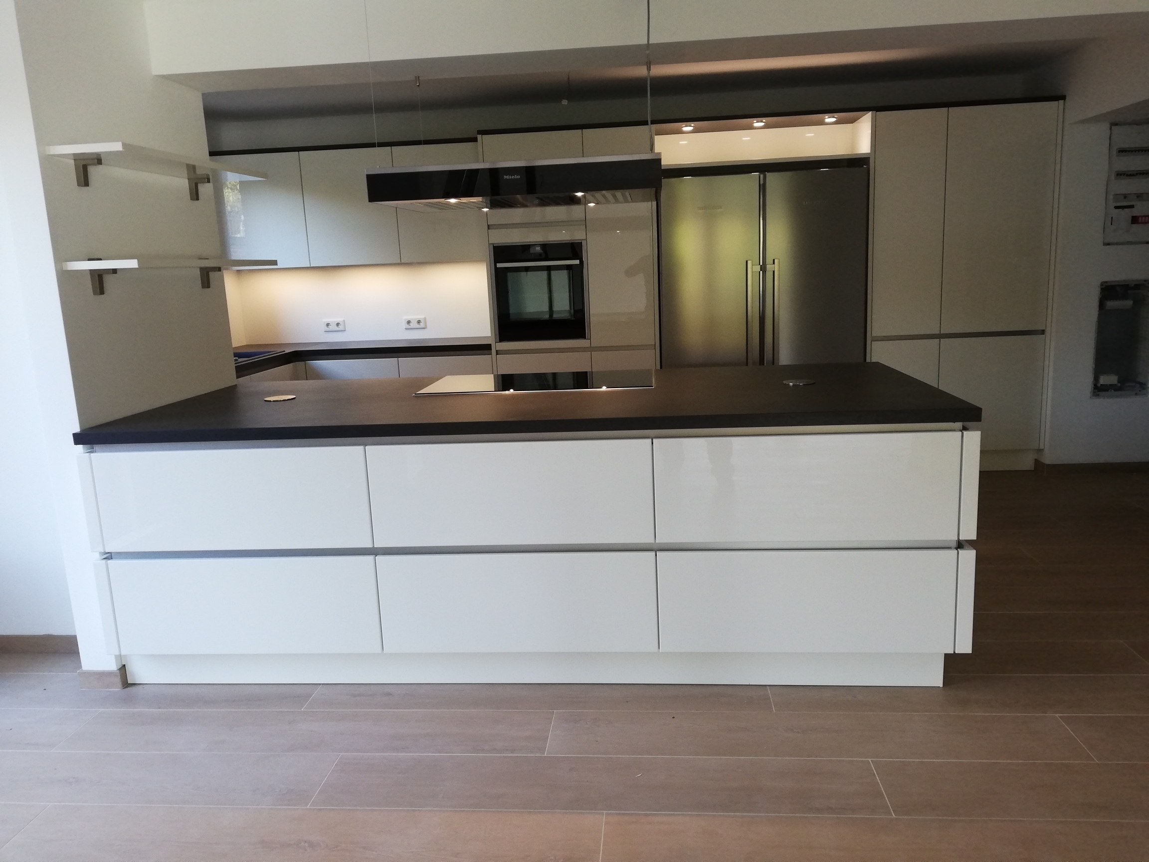 weiße Grifflosküche mit einer großen Kücheninsel